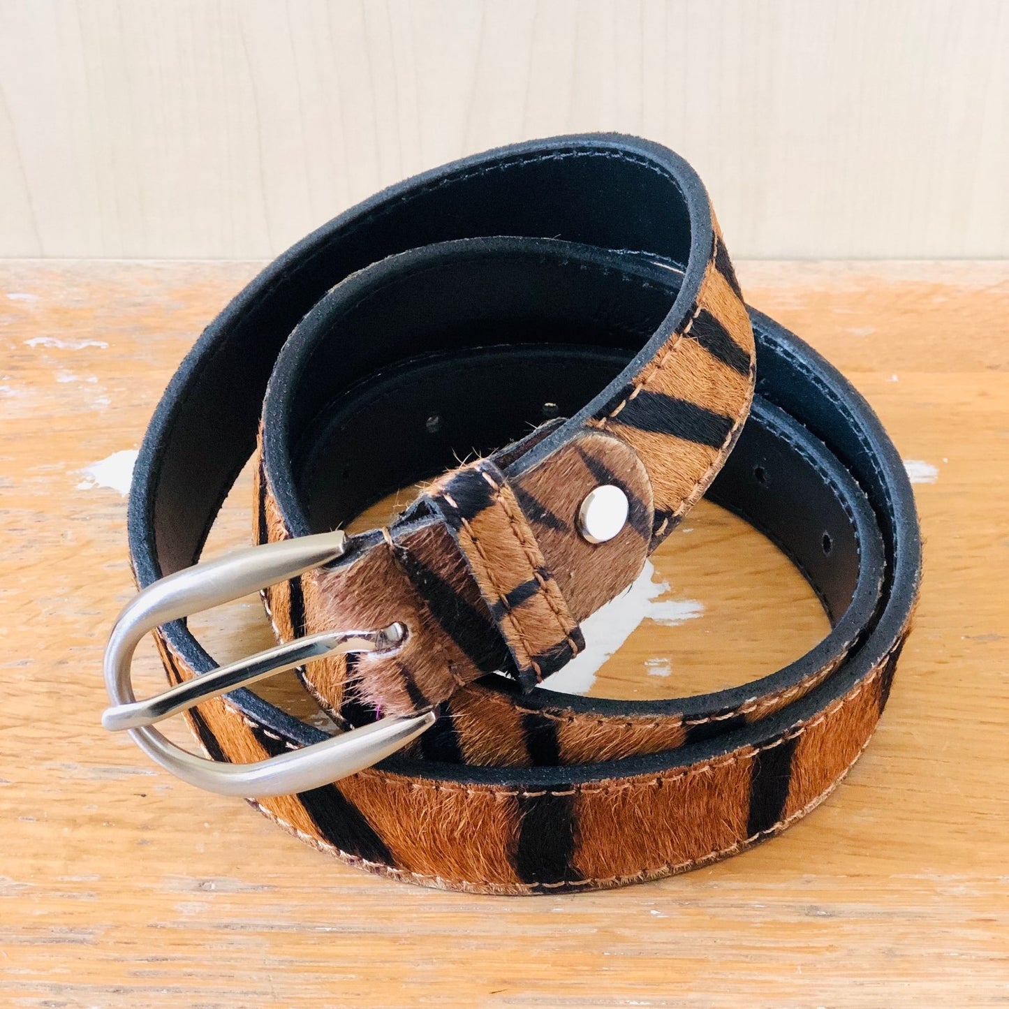 Light Tiger hair-on-hide leather belt on Table