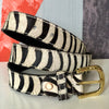 rolled zebra print leather belt on table